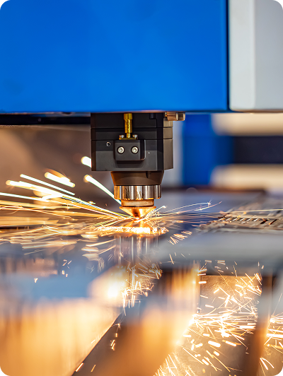Close-up of a laser cutting machine in operation, with sparks flying from the metal surface as it is being cut