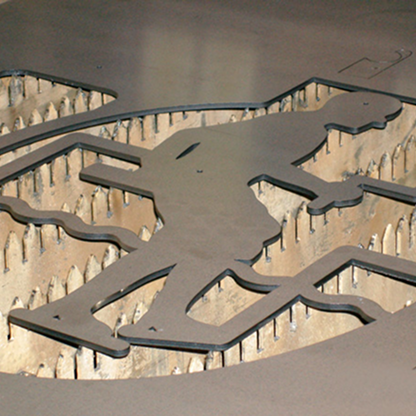 Laser-cut metal design featuring a figure of a man, surrounded by small metal spikes creating a textured background effect.